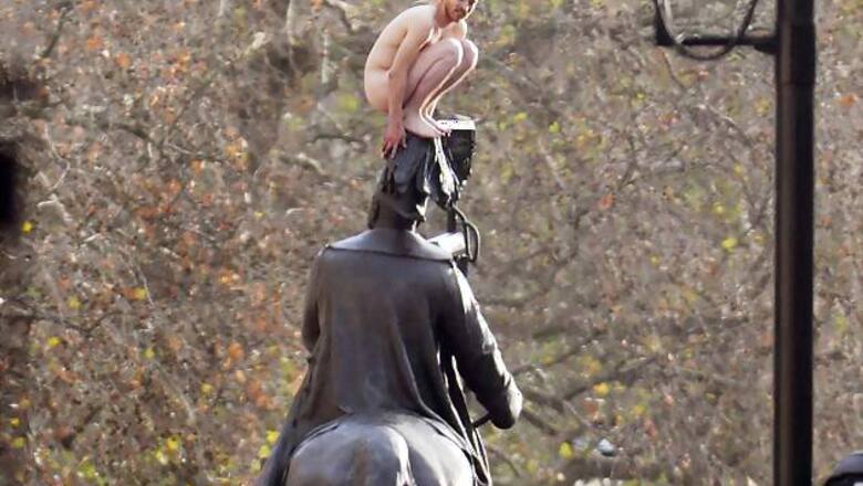 UK: Naked man climbs atop a statue near PM's house